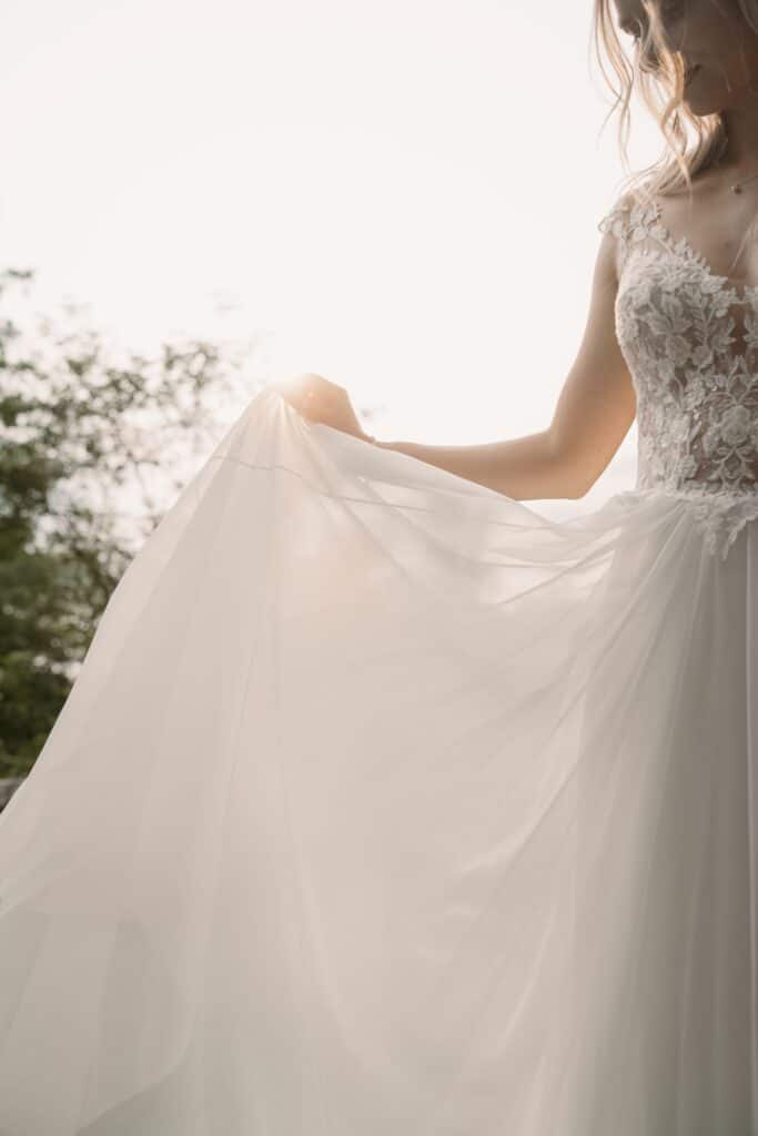 Braut in Spitzenkleid im Sonnenlicht