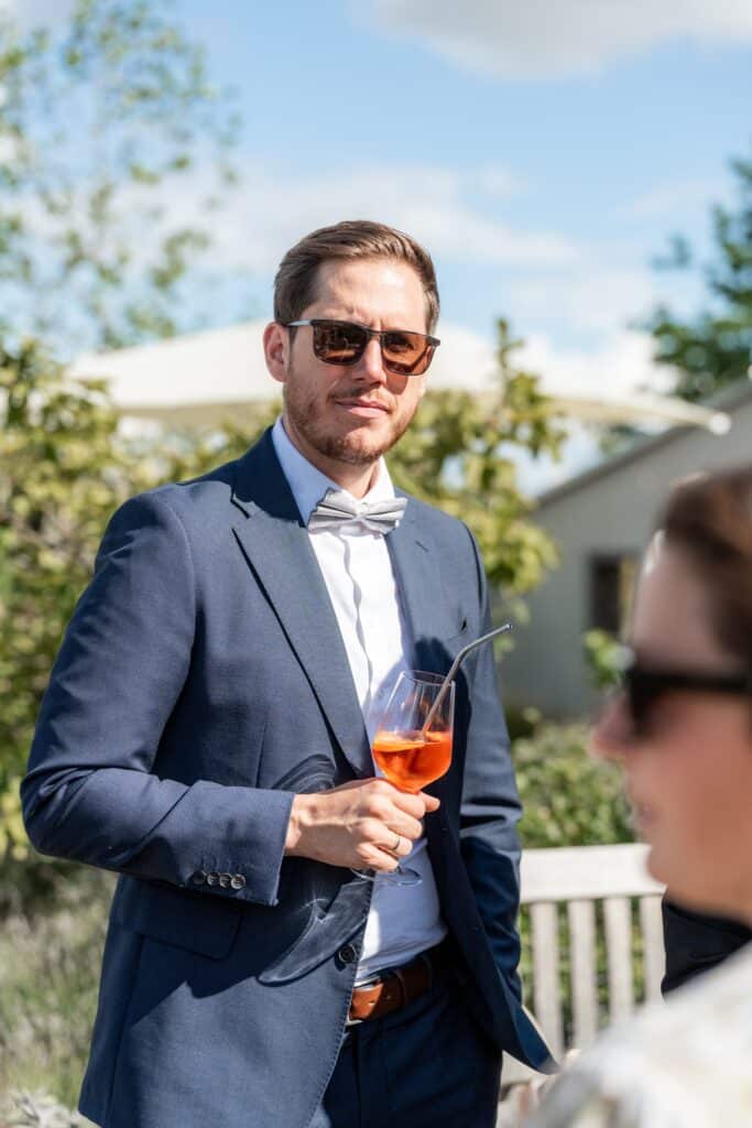 Hochzeitsgast mit Cocktail im Garten