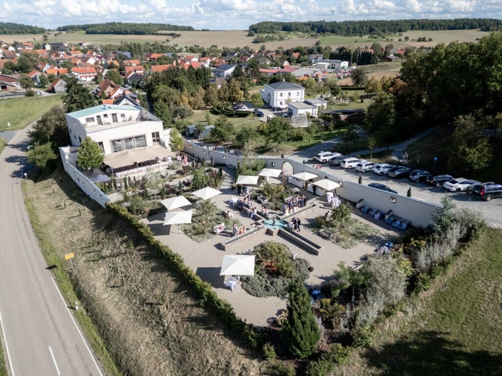 Gartenhochzeit mit Gästen und Sonnenschirmen im Freien
