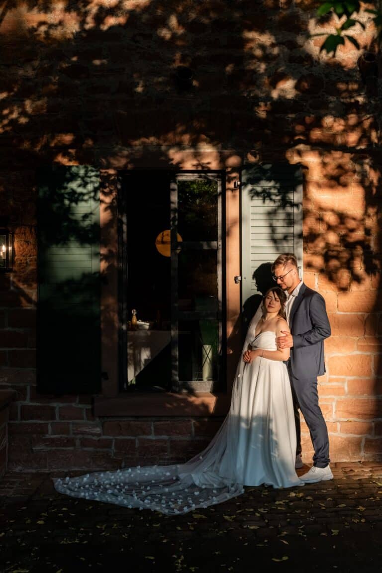 04787-florian-knusper-hochzeitsfotograf-wuerzburg-brautpaar-vor-gebaeude-hofgut hünnersdorf