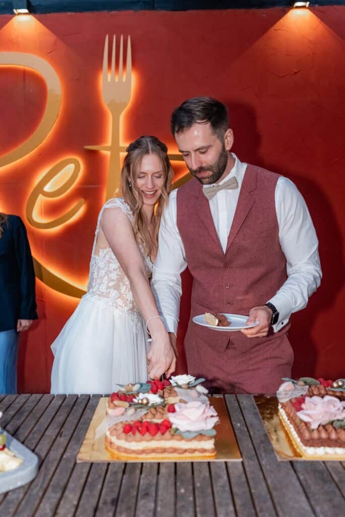 Brautpaar schneidet Hochzeitstorte an.