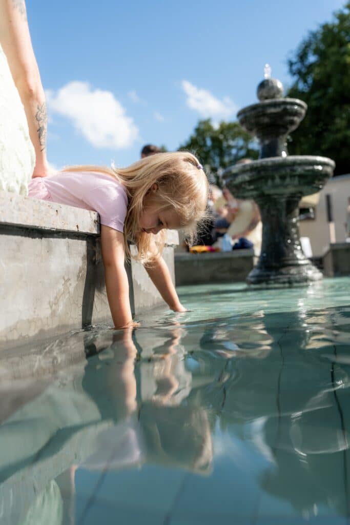 Kind spielt am Brunnen auf Hochzeit im Freien.