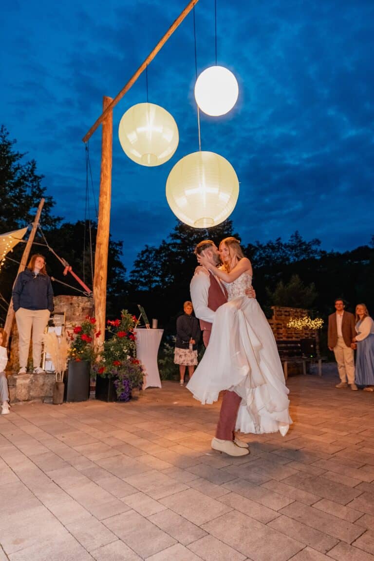 05179-florian-knusper-hochzeitsfotograf-wuerzburg-paar-tanzt-unter-laternen-Das Retz