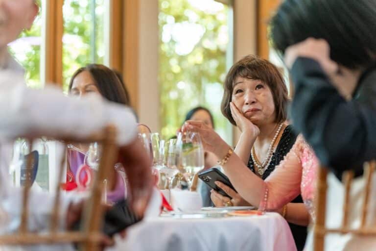 05558-florian-knusper-hochzeitsfotograf-wuerzburg-gaeste-am-tisch-Hotel Schindlerhof Nuernberg