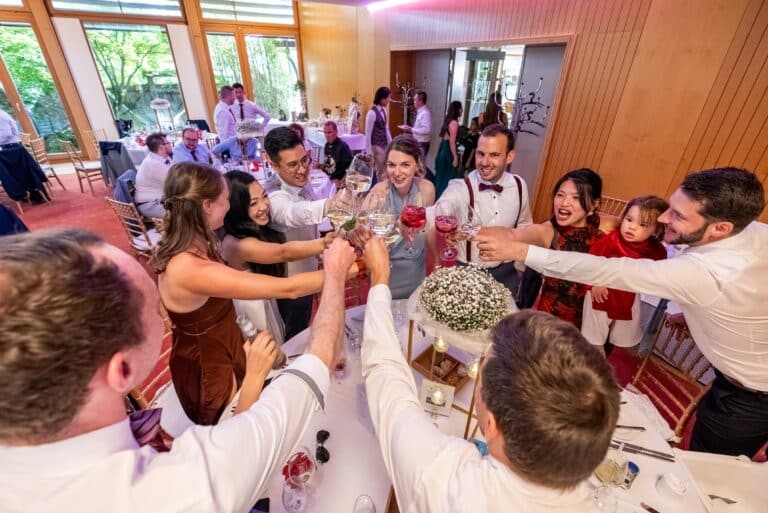 05809-florian-knusper-hochzeitsfotograf-wuerzburg-gaeste-beim-anstossen-Hotel Schindlerhof Nuernberg