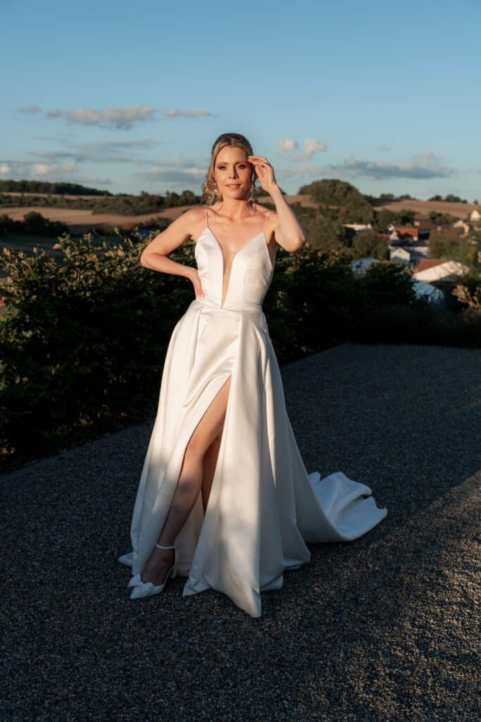 Braut im weißen Kleid bei Sonnenuntergang draußen