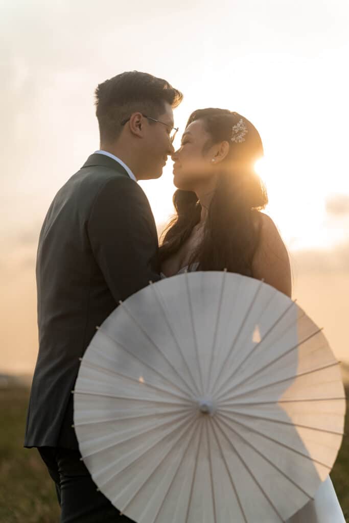 Brautpaar mit Schirm im Sonnenuntergang Hotel Schindlerhof
