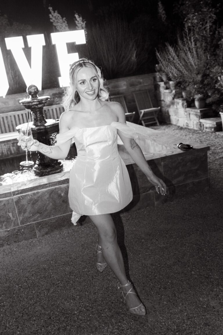 06394-2-florian-knusper-hochzeitsfotograf-wuerzburg-frau-mit-getraenk-vor-love-schild-villa-oriental