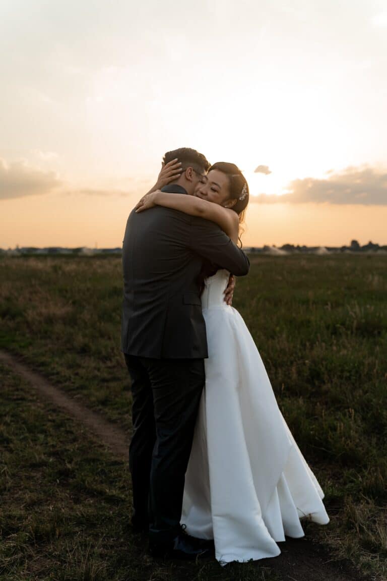 06409-florian-knusper-hochzeitsfotograf-wuerzburg-brautpaar-umarmung-im-feld-Hotel Schindlerhof Nuernberg