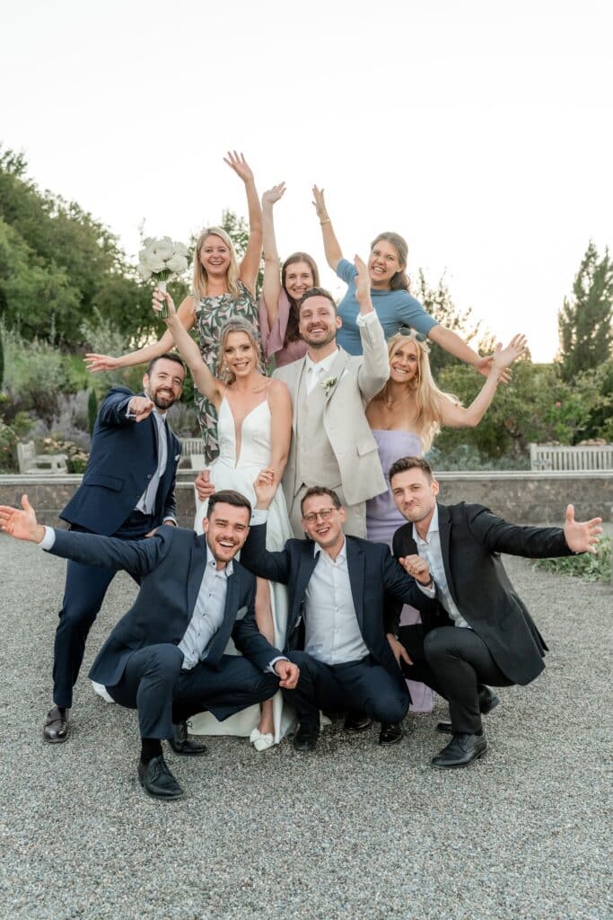Gruppe von Hochzeitsgästen im Garten feiert zusammen.
