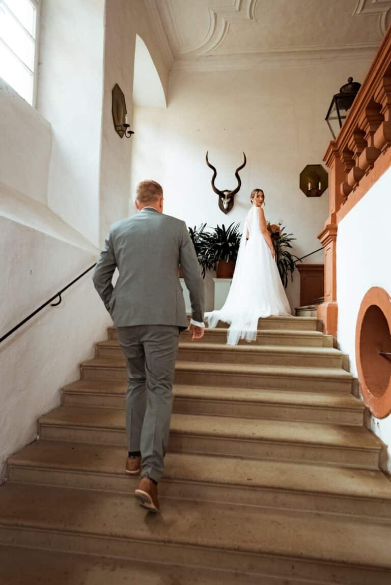 1-florian-knusper-hochzeitsfotograf-wuerzburg-brautpaar-auf-treppe-01522_-Schloss Zeilitzheim