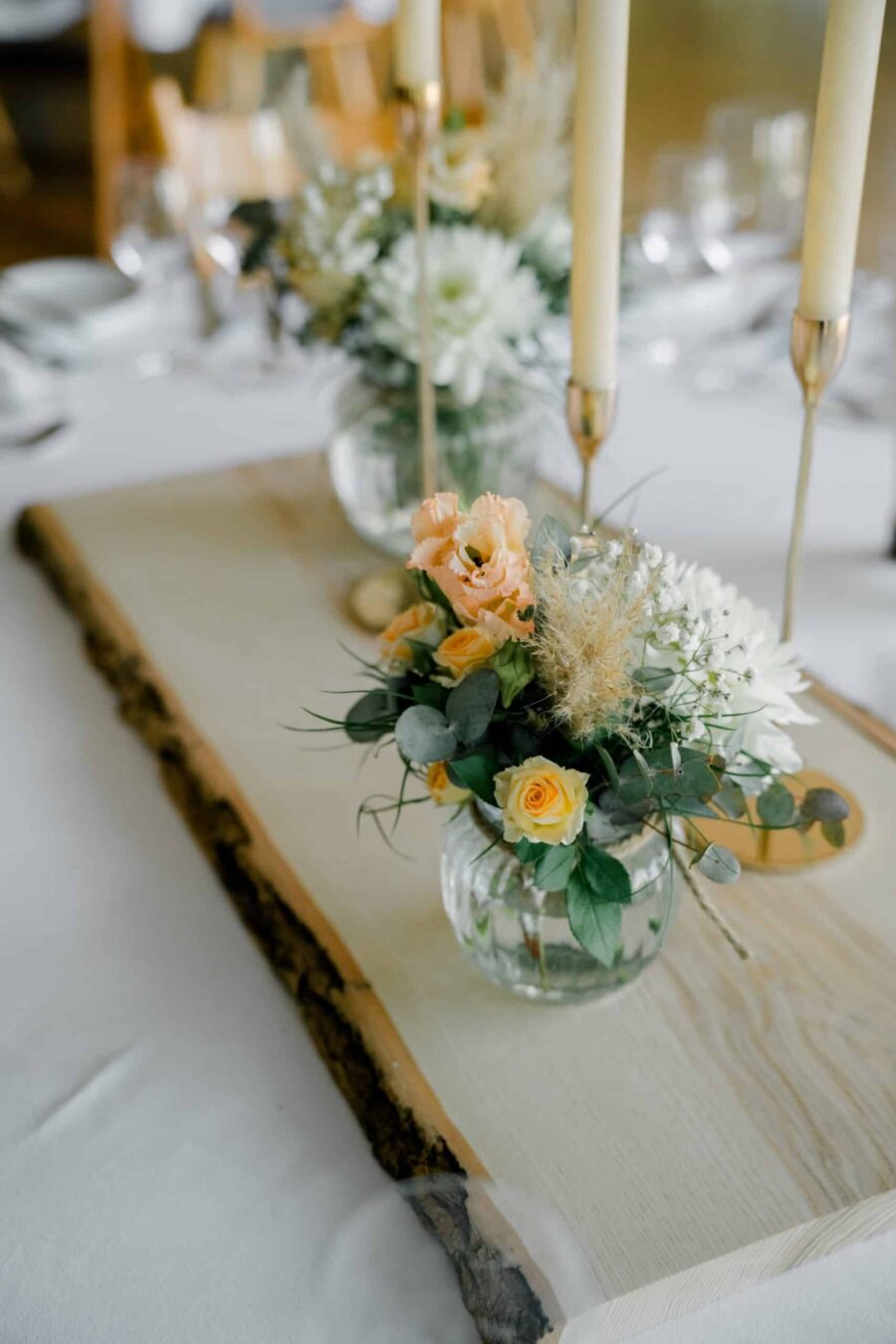 Blumendekoration mit Kerzen auf Hochzeitstisch