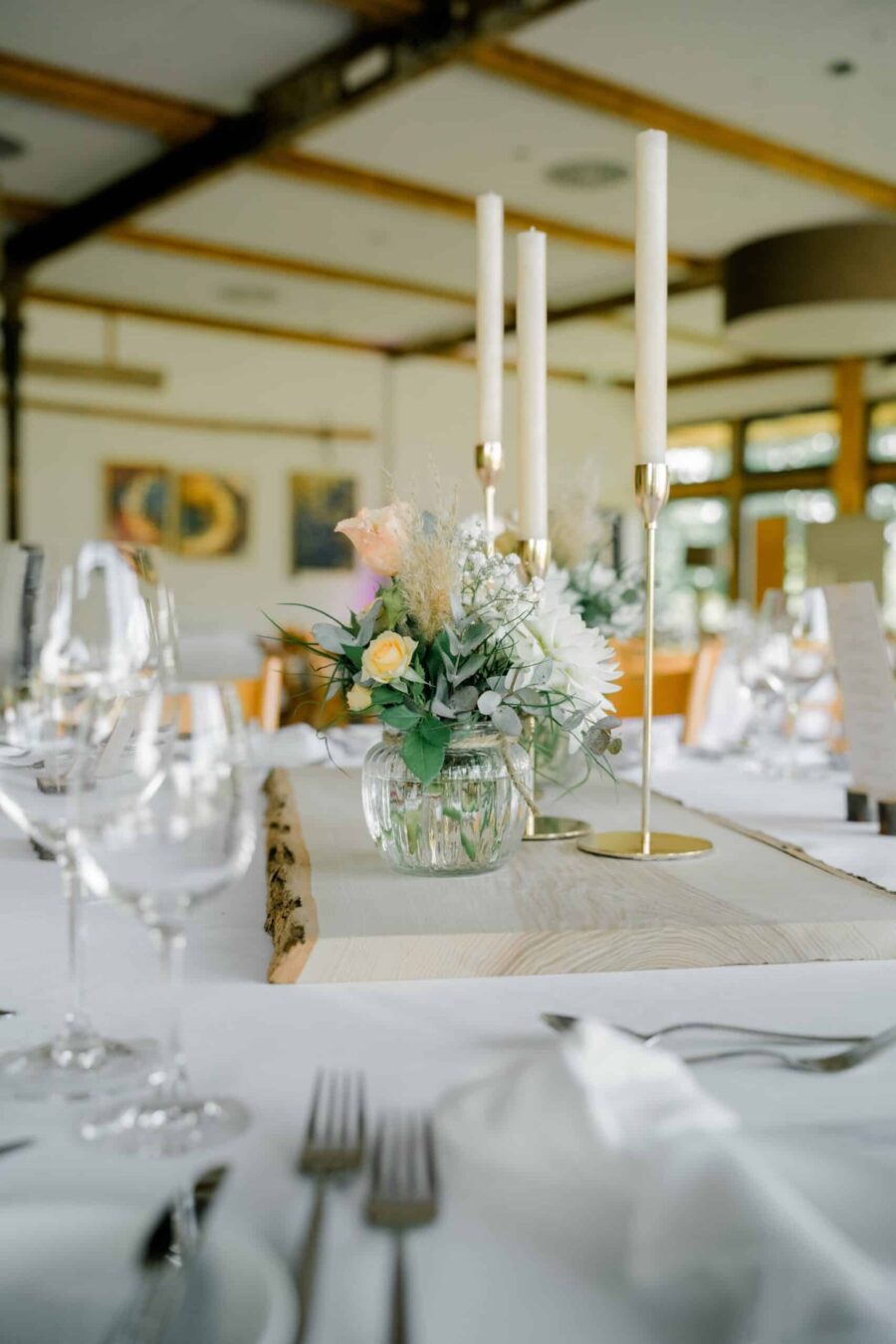 Elegante Tischdekoration mit Blumen und Kerzenständern.