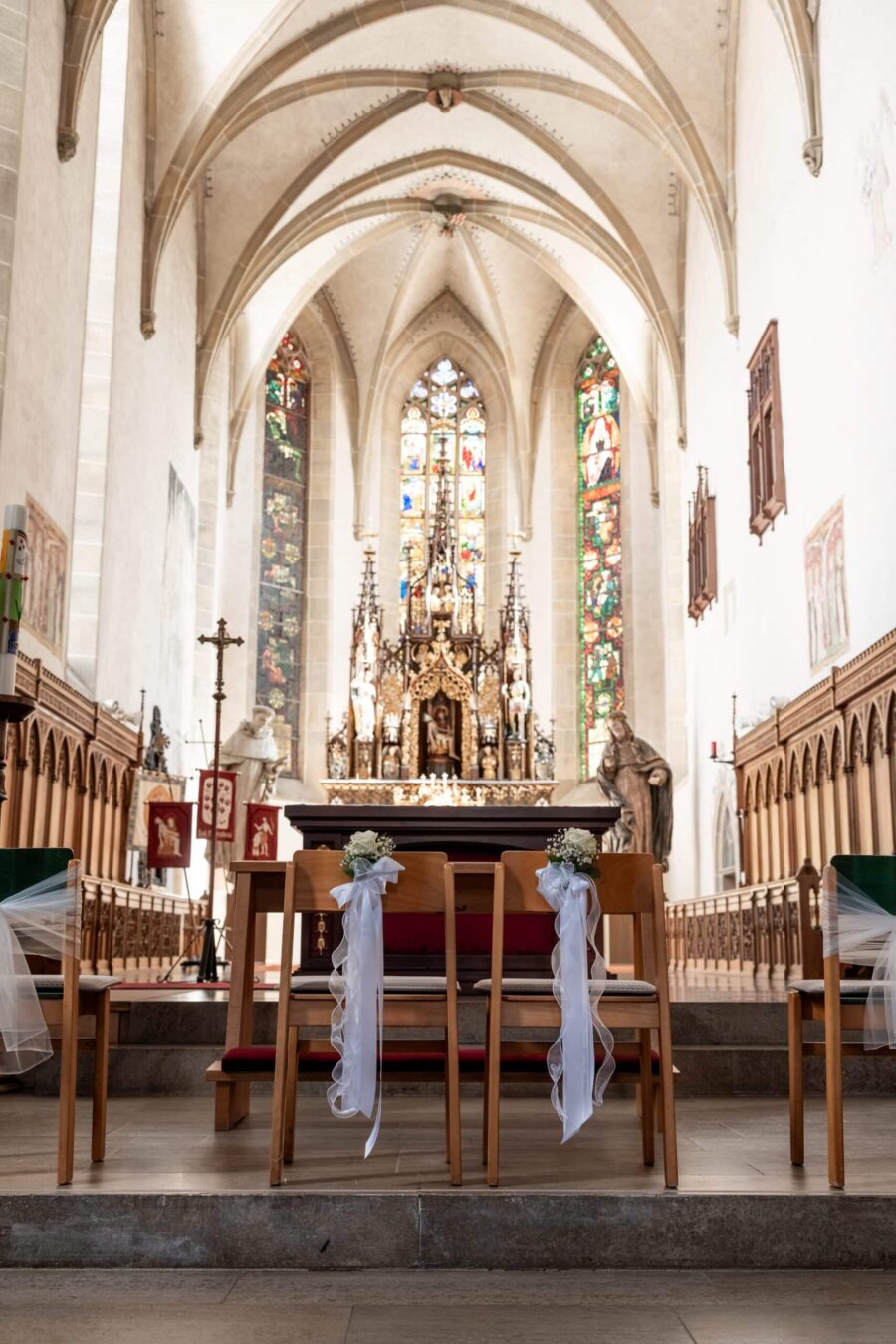 Kirchenaltar mit geschmückten Sitzreihen.