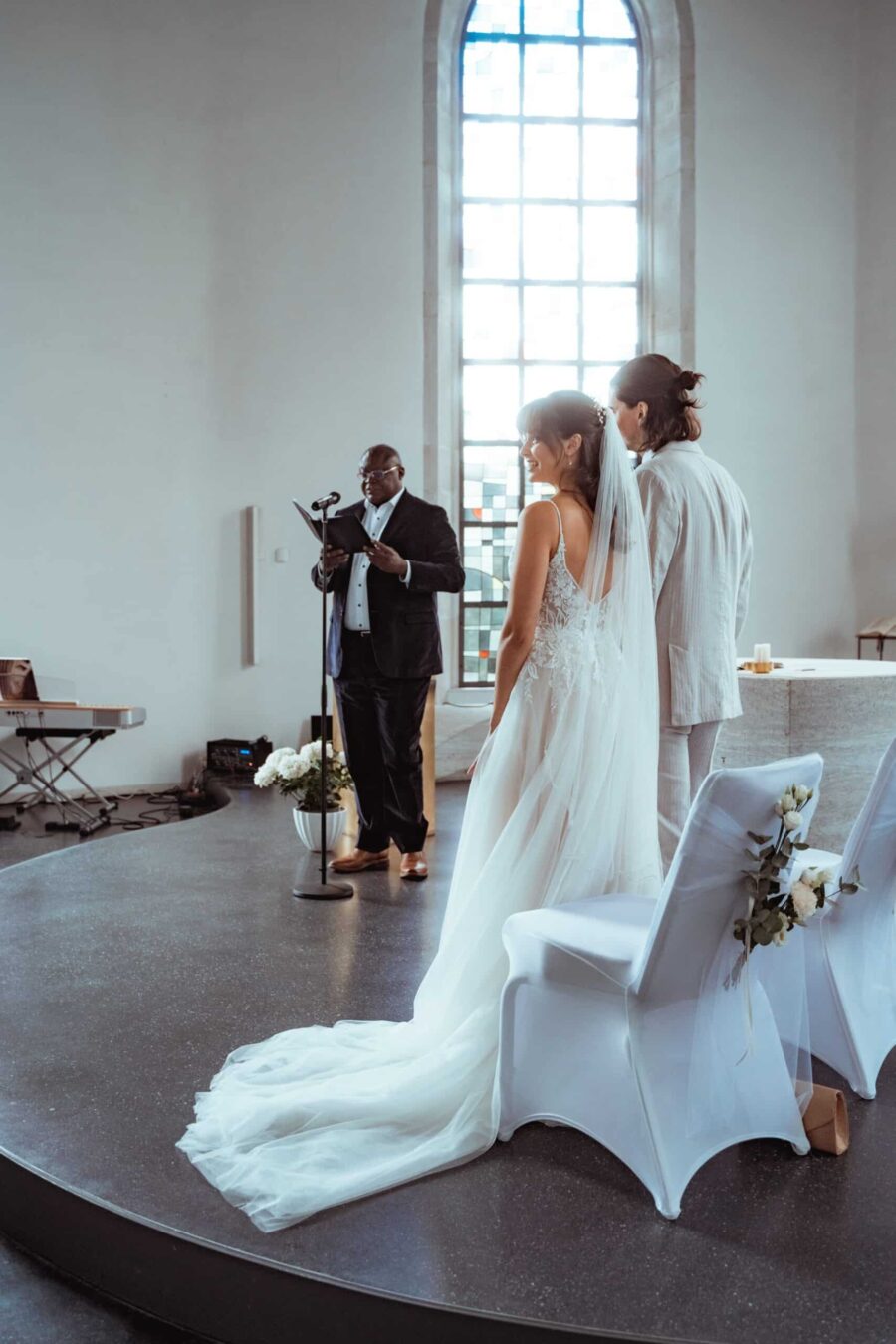 Brautpaar vor Trauredner in heller Kapelle