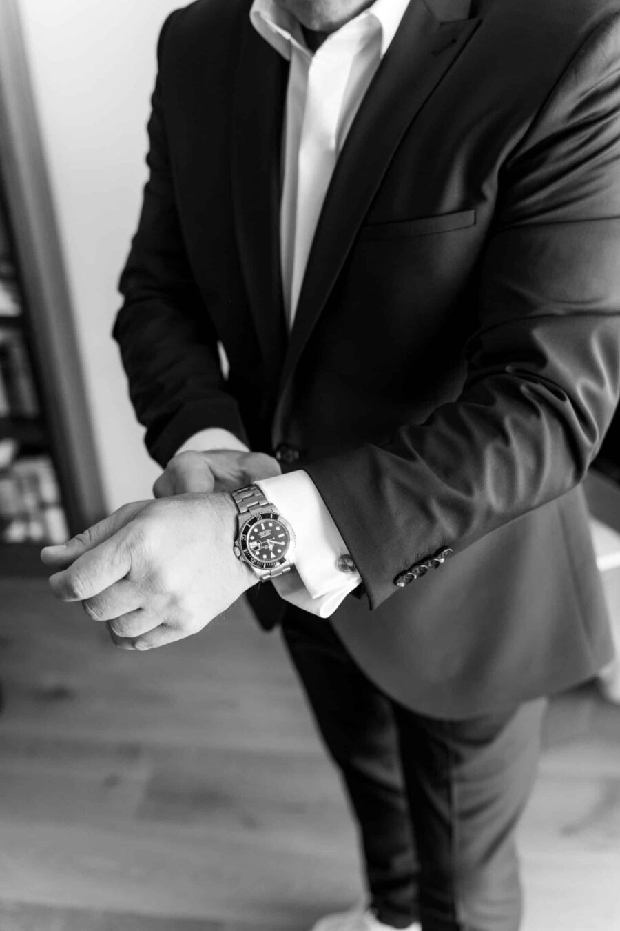 Mann im Anzug mit Uhr stellt sie ein