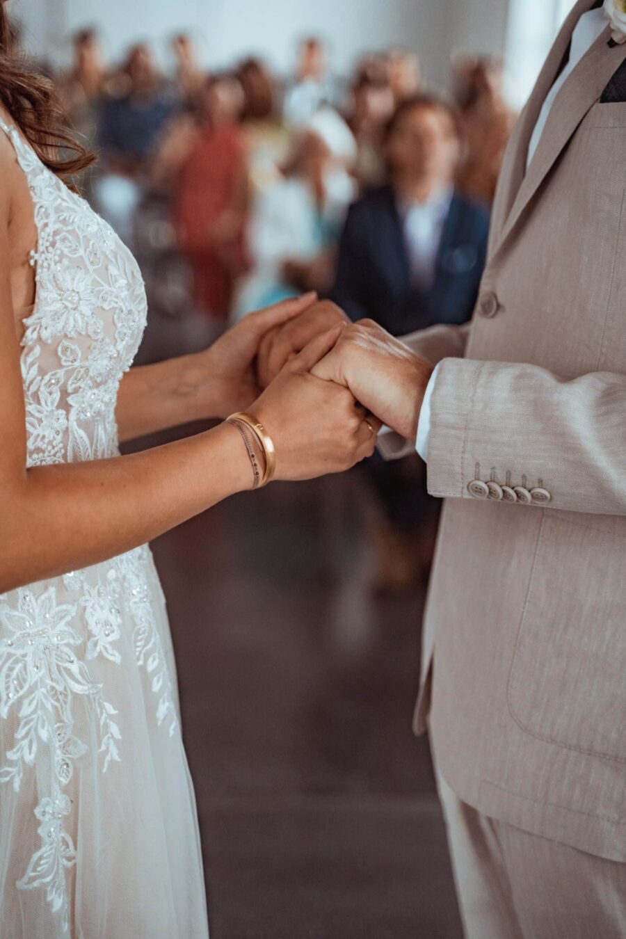 Brautpaar hält Hände während der Trauung.