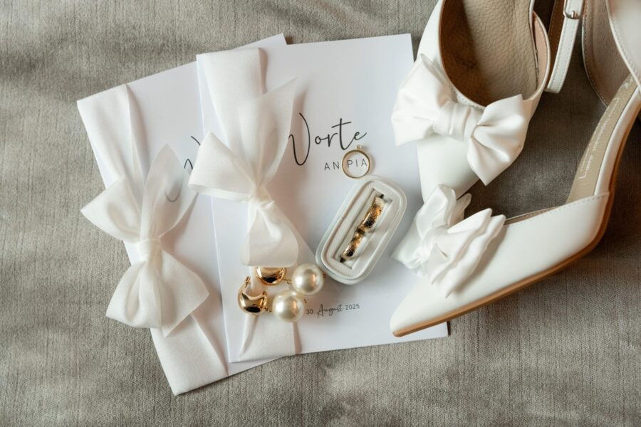 Brautschuhe und Trauringe mit Hochzeitseinladungen