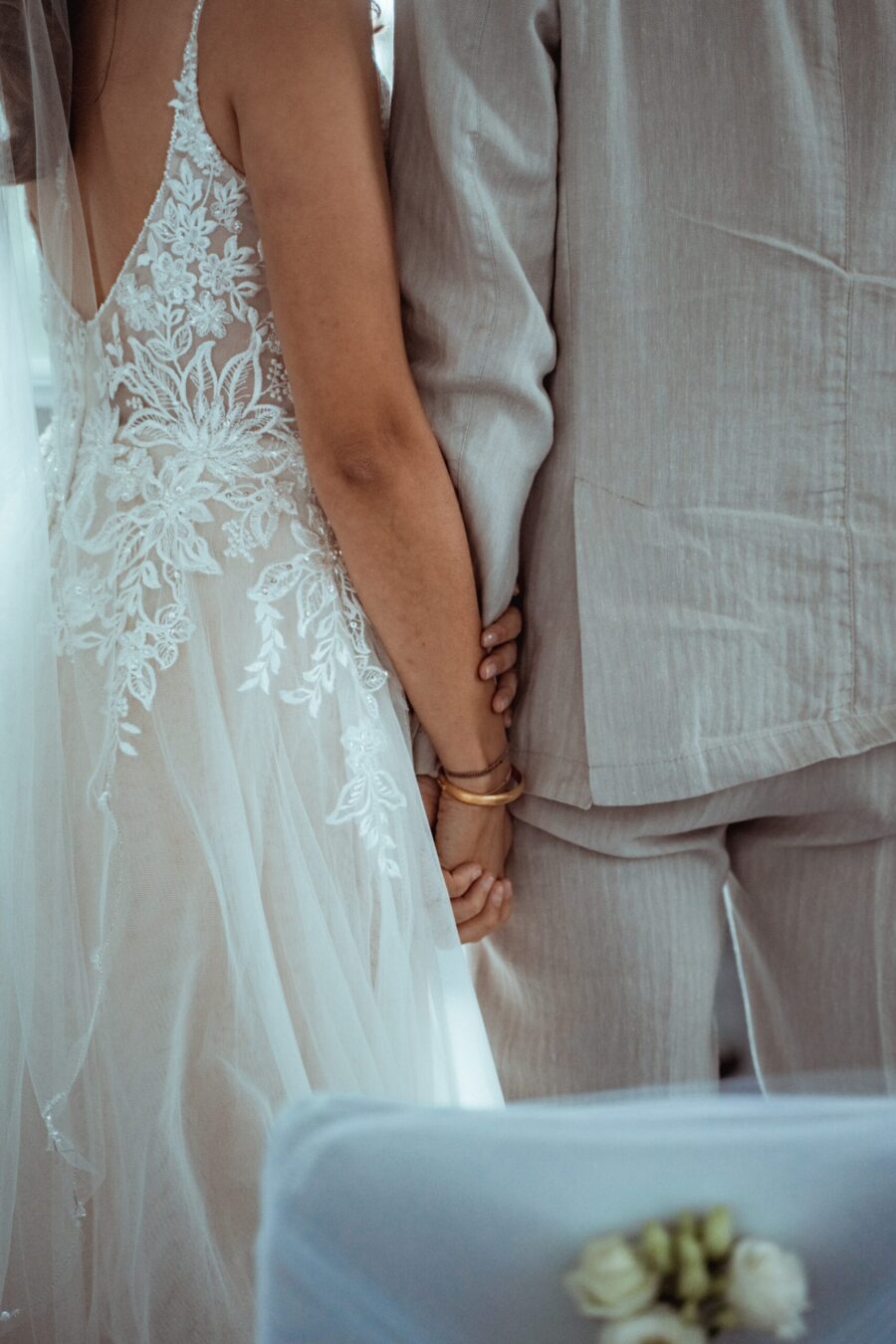 Brautpaar Hand in Hand in Hochzeitskleidung