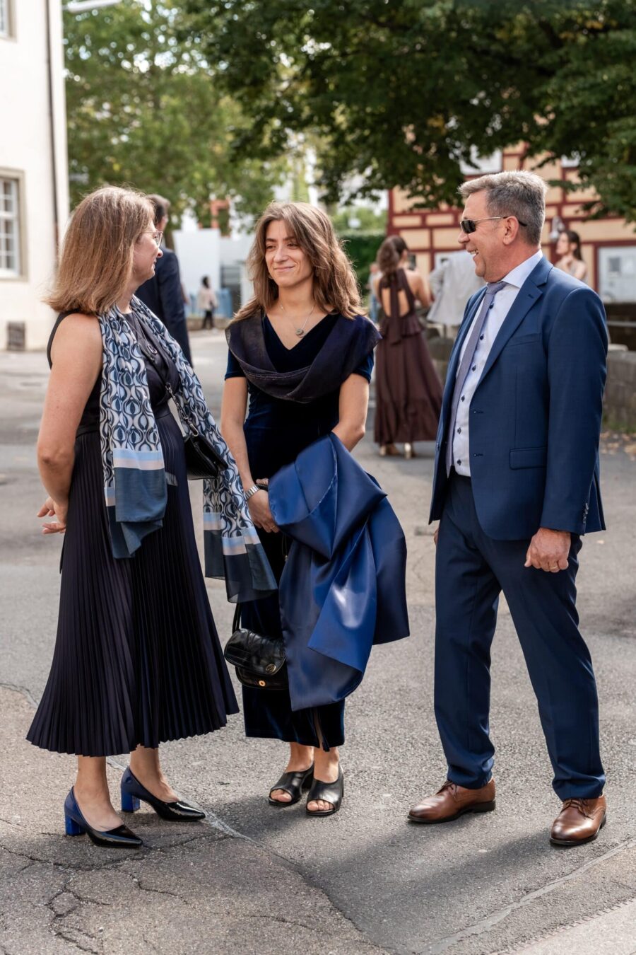 Gäste plaudern elegant gekleidet im Freien