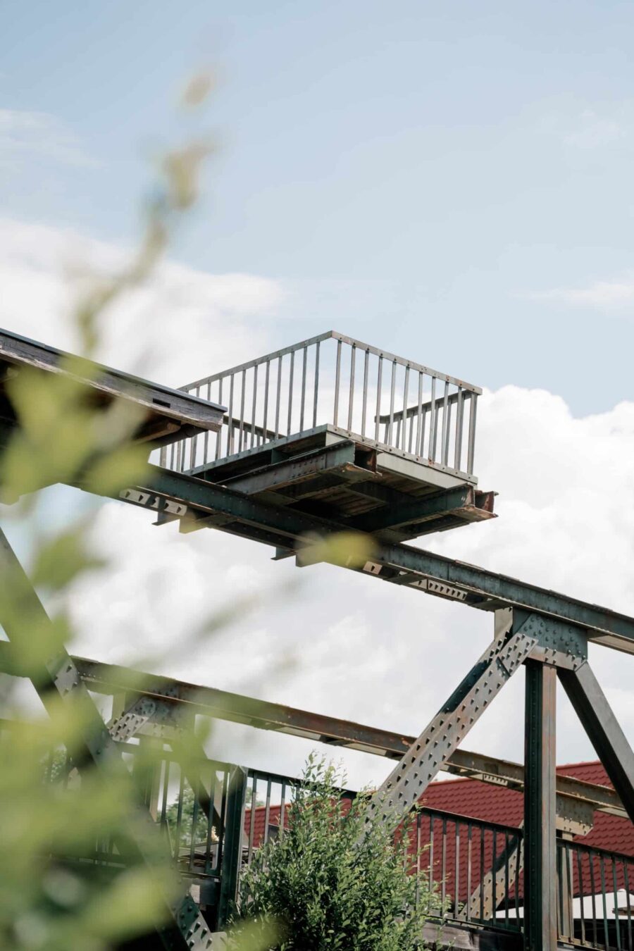 Industriedetail mit grünem Blattwerk und Himmel