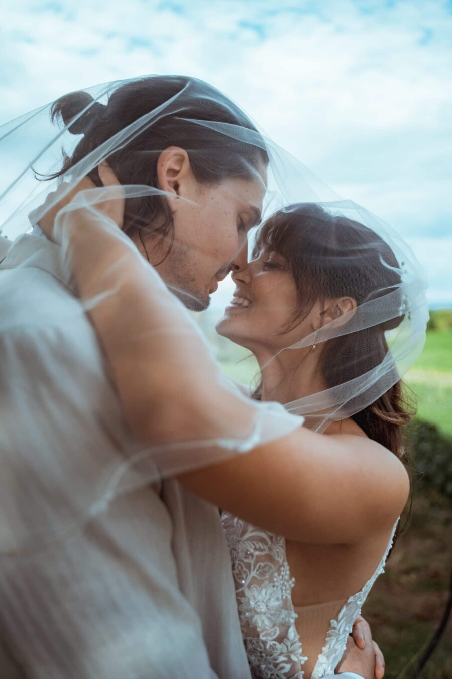 Brautpaar unter Schleier bei Sommerhochzeit