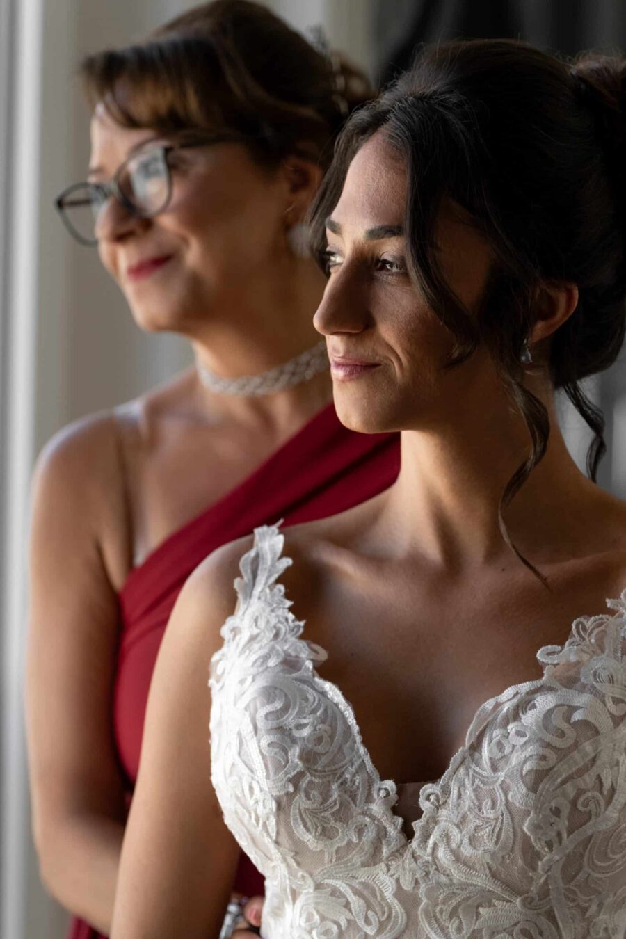 Braut in weiß mit Begleiterin in rotem Kleid