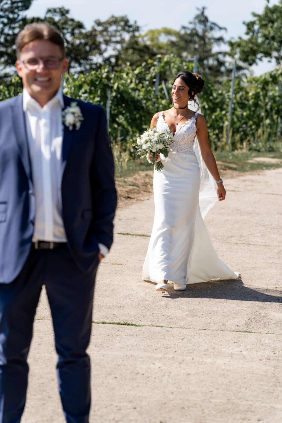 Braut im weißen Kleid auf Sommerweg im Freien
