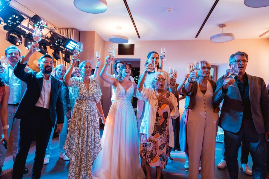 Gäste stoßen mit Gläsern bei Hochzeit an