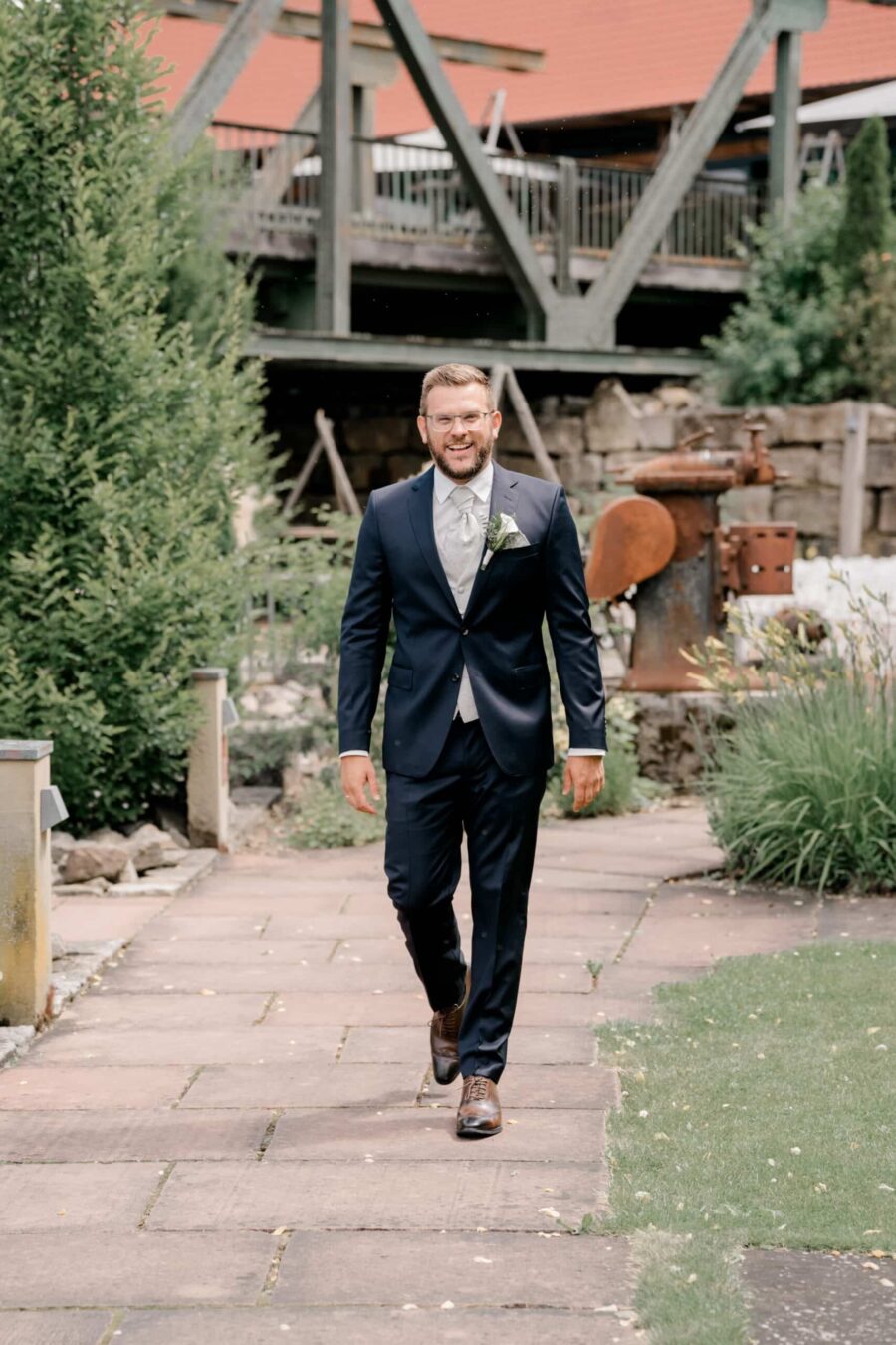 Mann im Anzug auf Gartenweg bei Hochzeitsfeier