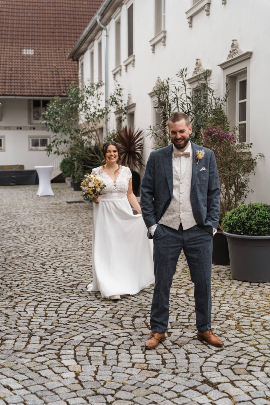 Brautpaar im Innenhof vor weißem Gebäude