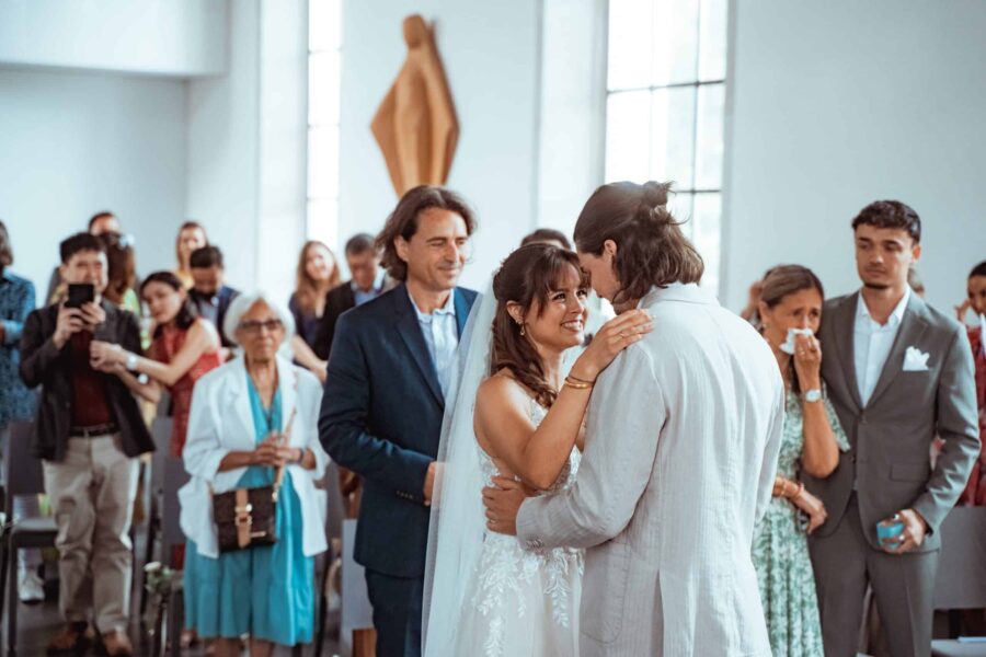 Brautpaar umgeben von Gästen in einer Kirche
