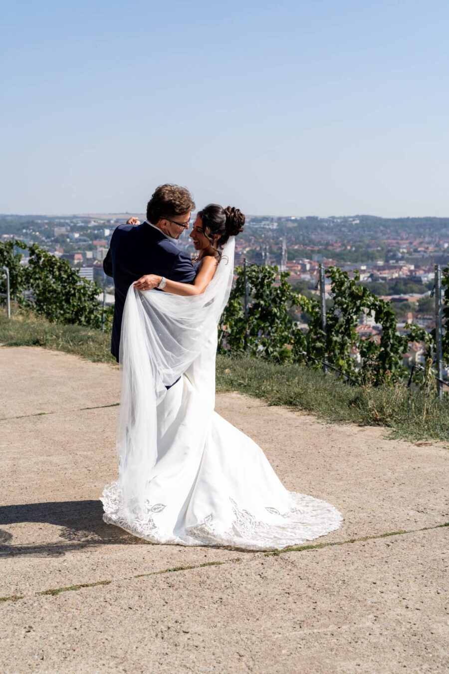 Brautpaar tanzt im Freien mit Stadtblick
