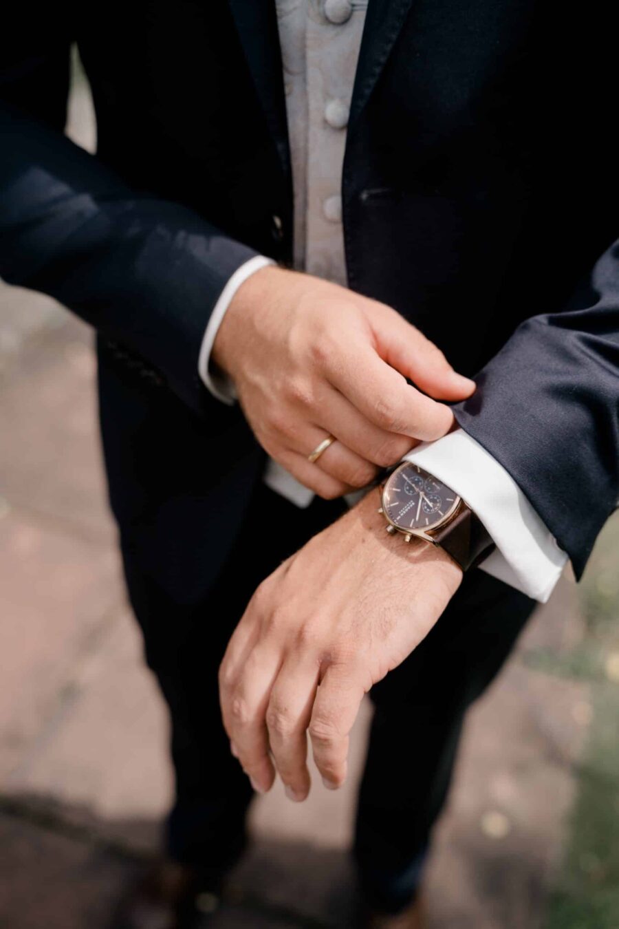 Mann im Anzug mit Uhr im Freien