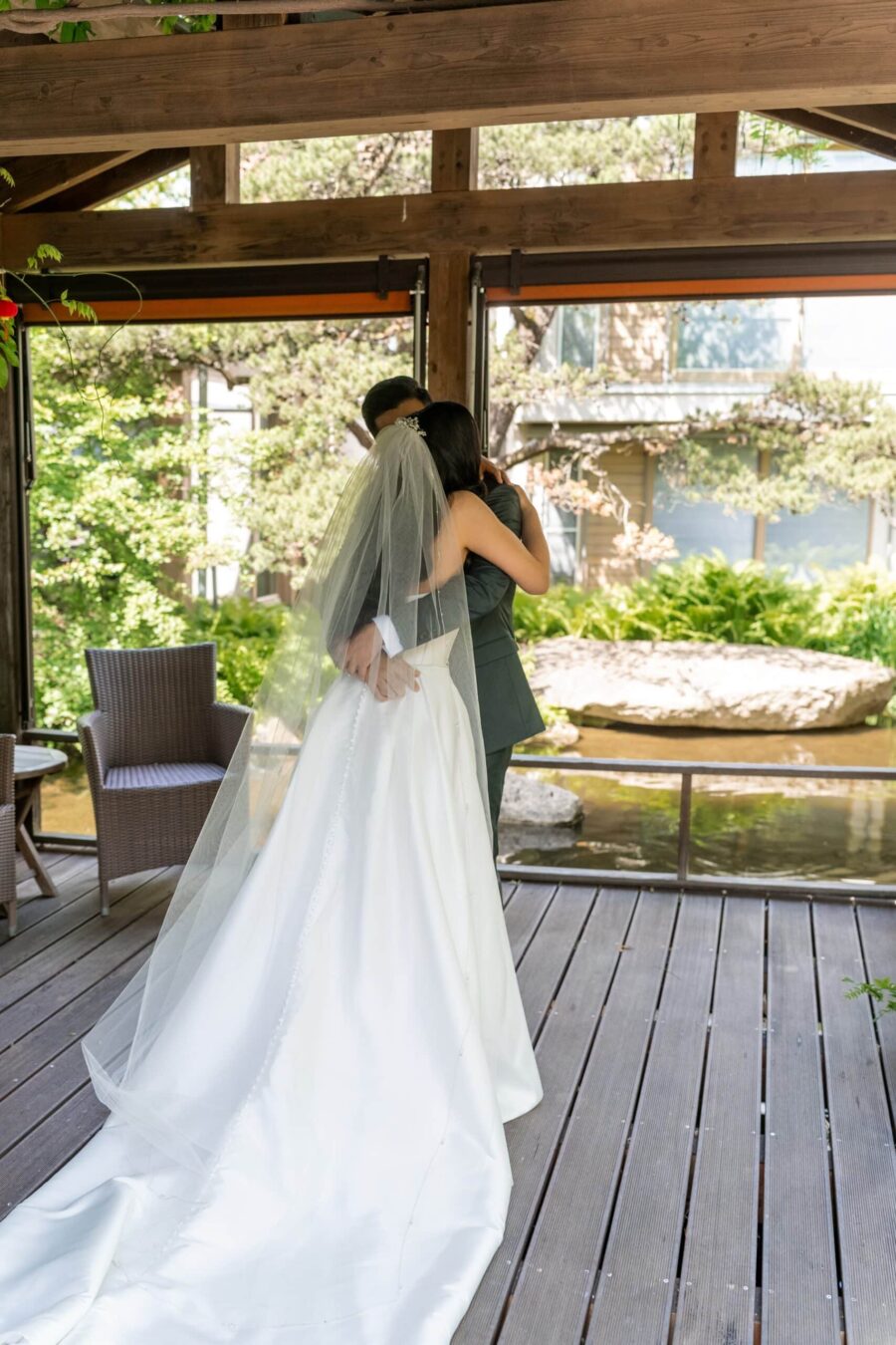 Brautpaar umarmt sich im Gartenpavillon