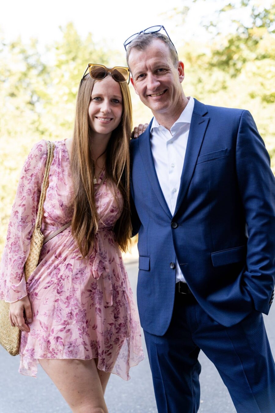 Gästepaar in eleganter Kleidung draußen.