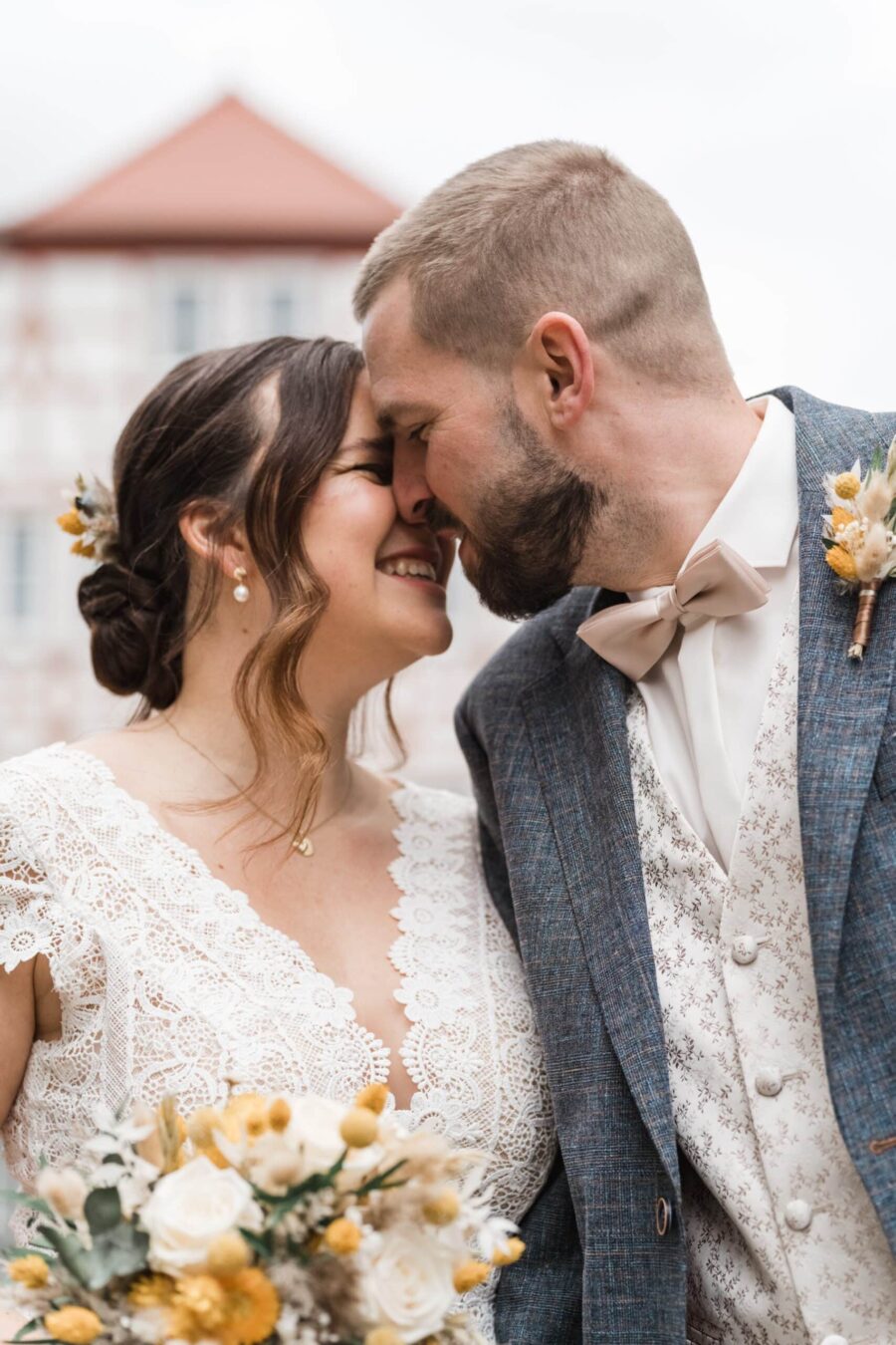 Brautpaar lächelt und umarmt sich im Freien