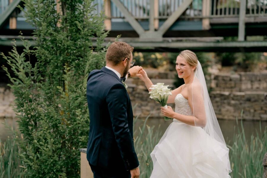 Brautpaar im Garten bei Brücke und Fluss.