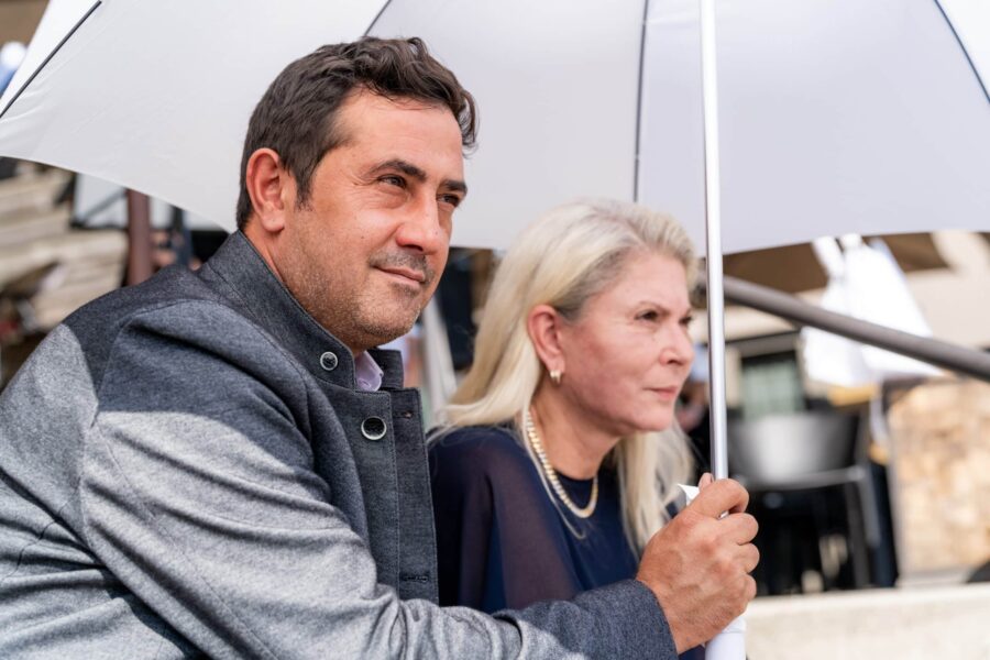 Gäste unter Regenschirm im Außenbereich