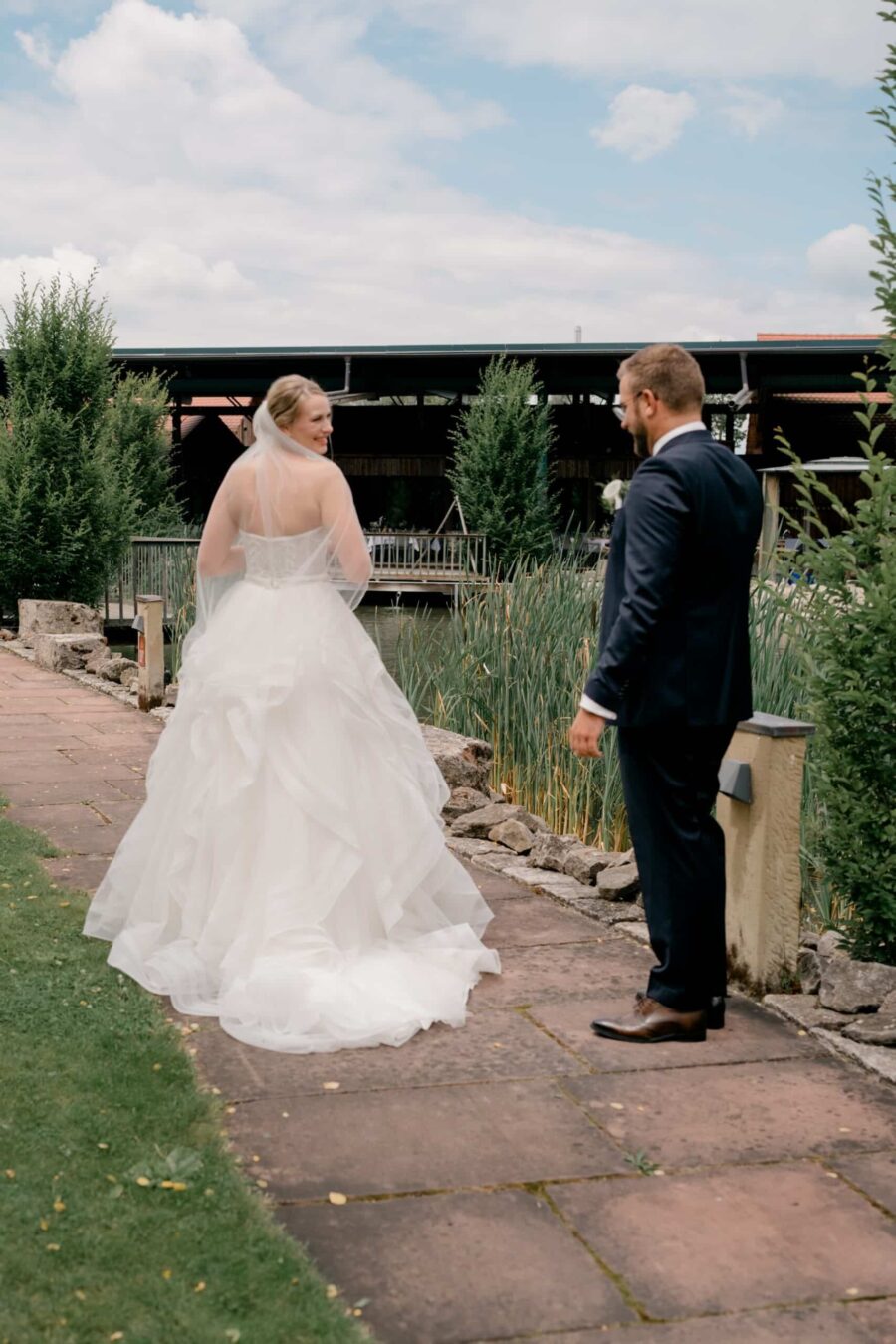 Brautpaar im Garten auf Steinweg bei Teich.