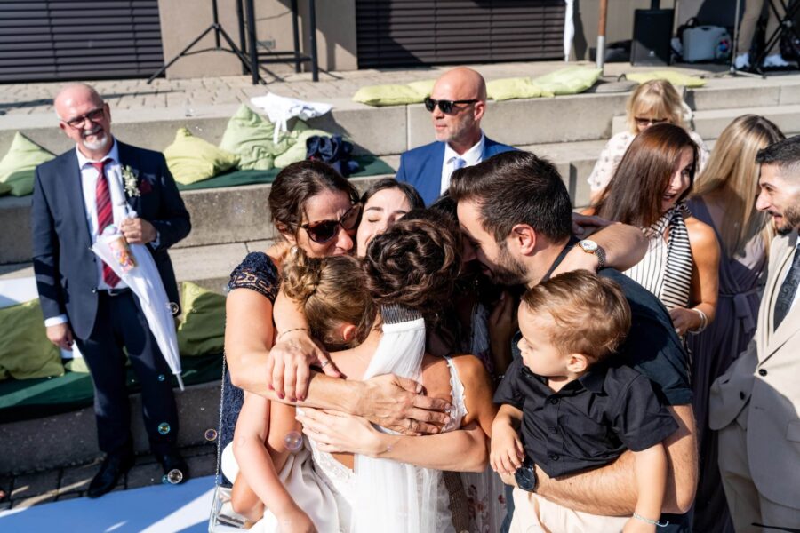 Gruppenumarmung bei Hochzeitsfeier im Freien