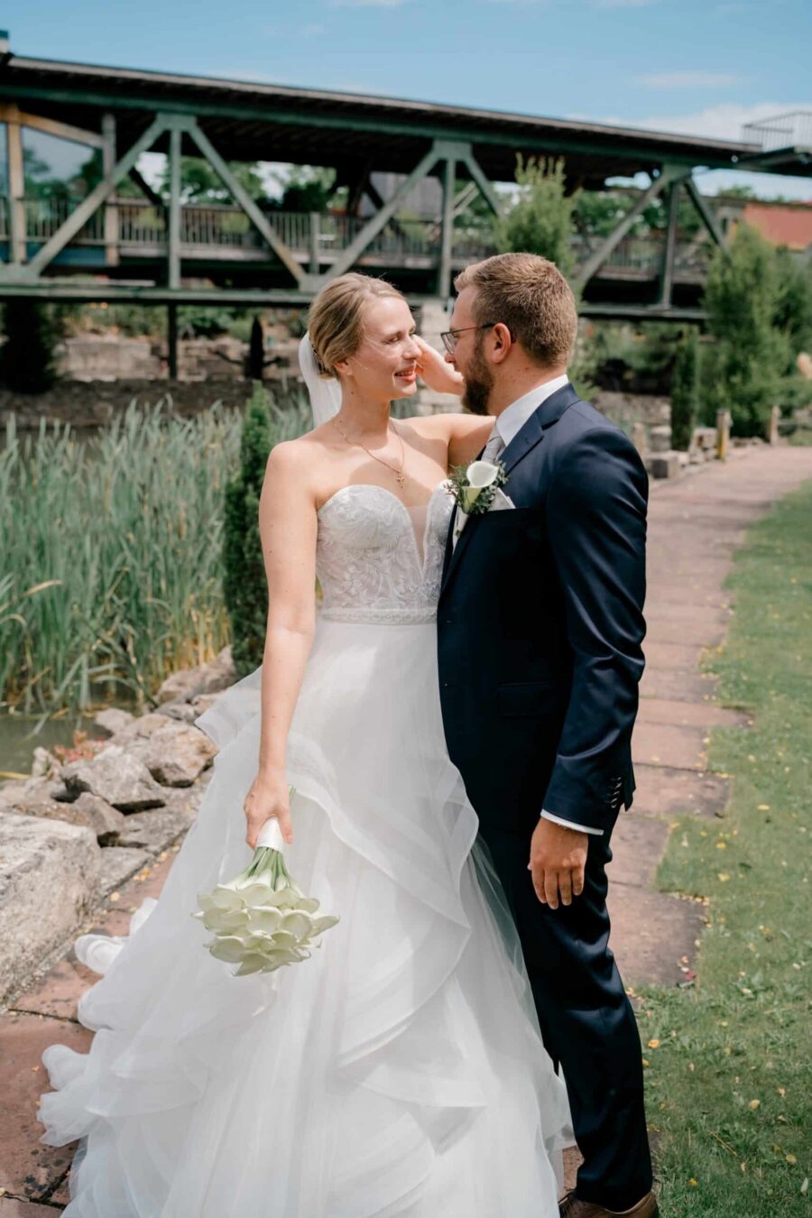 Brautpaar im Garten vor Holzbrücke