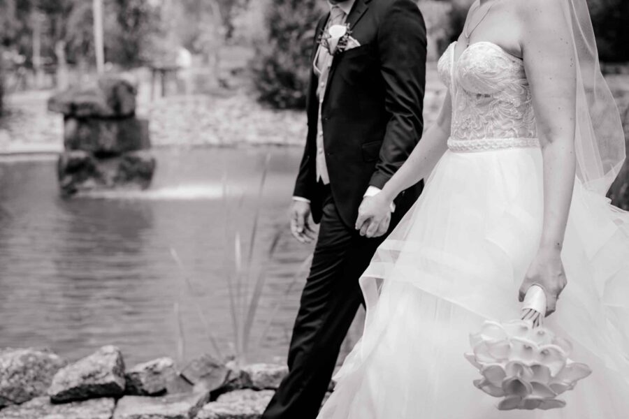 Brautpaar spaziert am Seeufer entlang‍