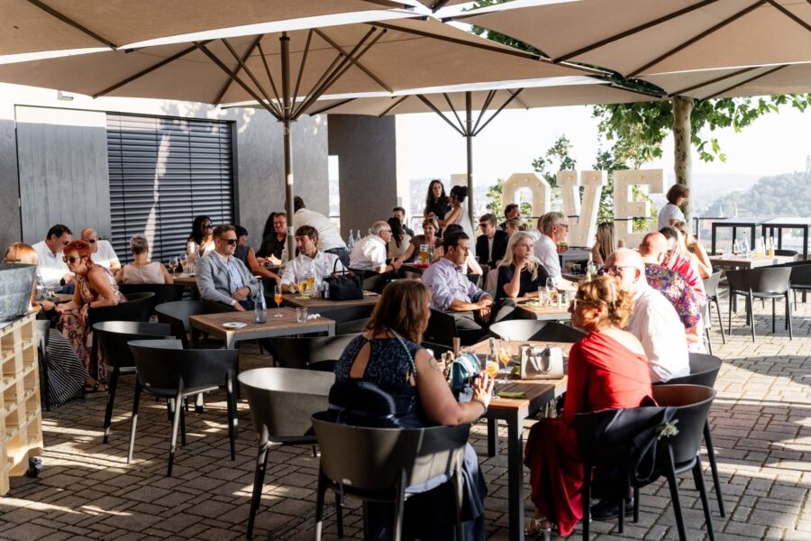Gäste sitzen bei Hochzeitsfeier im Außenbereich