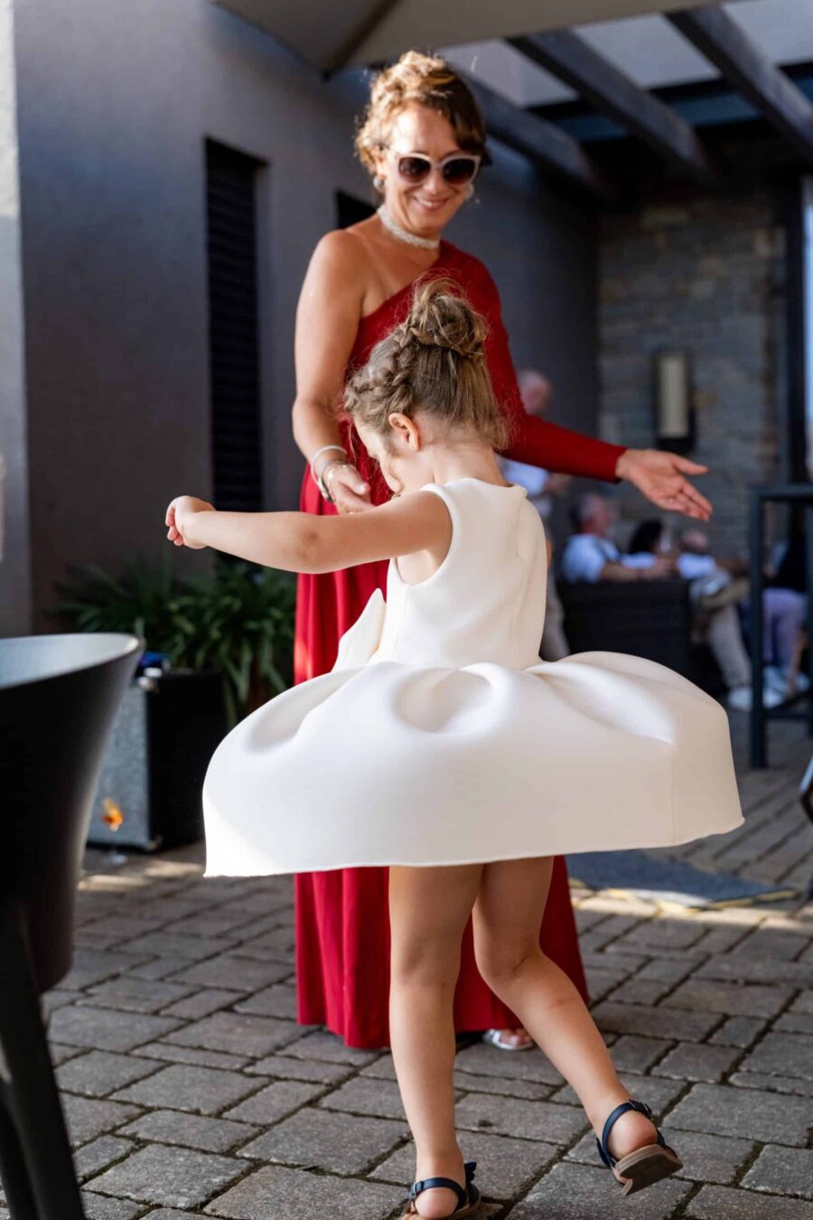 Kind in elegantem Kleid tanzt bei Hochzeit