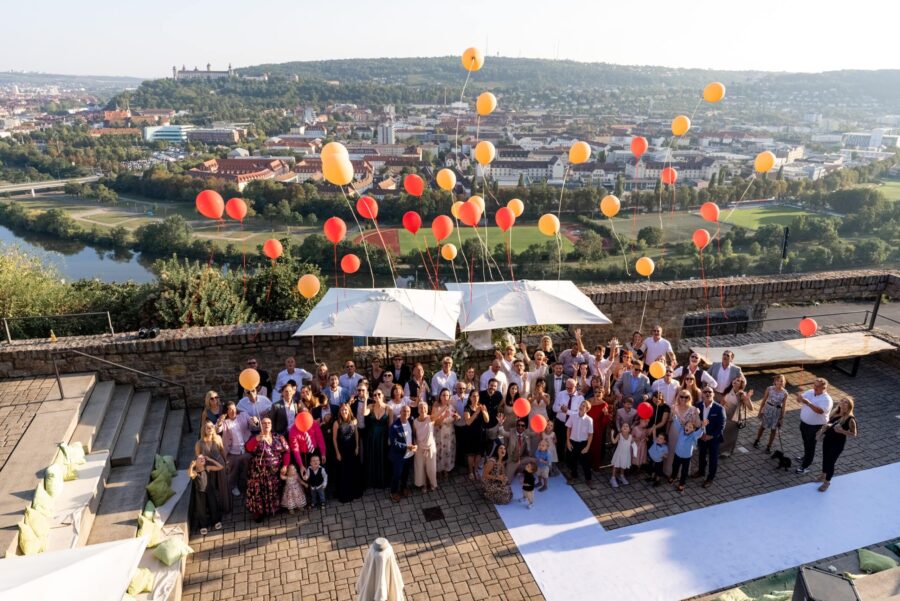 Hochzeitsgäste mit Luftballons im Freien