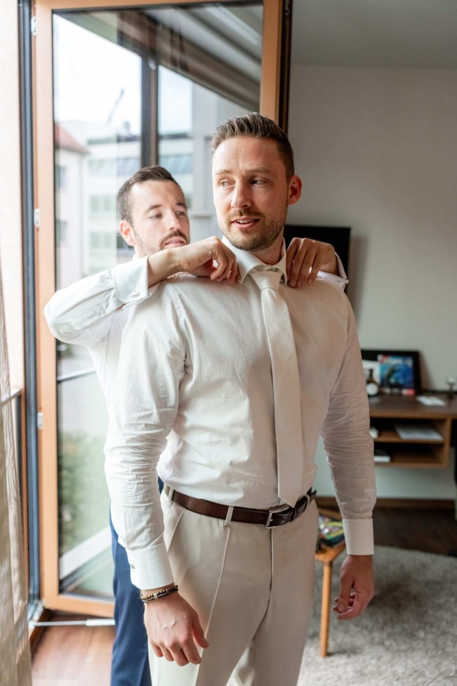 Bräutigam wird beim Ankleiden unterstützt
