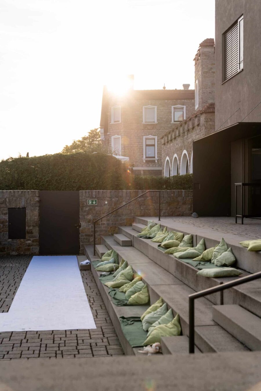 Sitzplätze mit Kissen in sonniger Hochzeitslocation im Freien