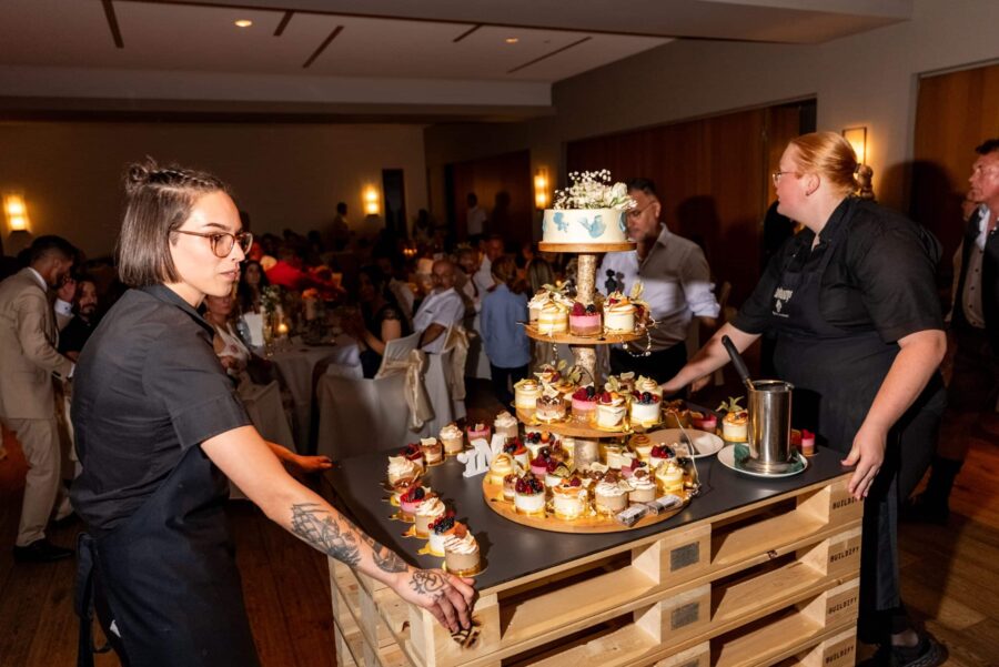 Hochzeitstorte mit Gästen im Festsaal