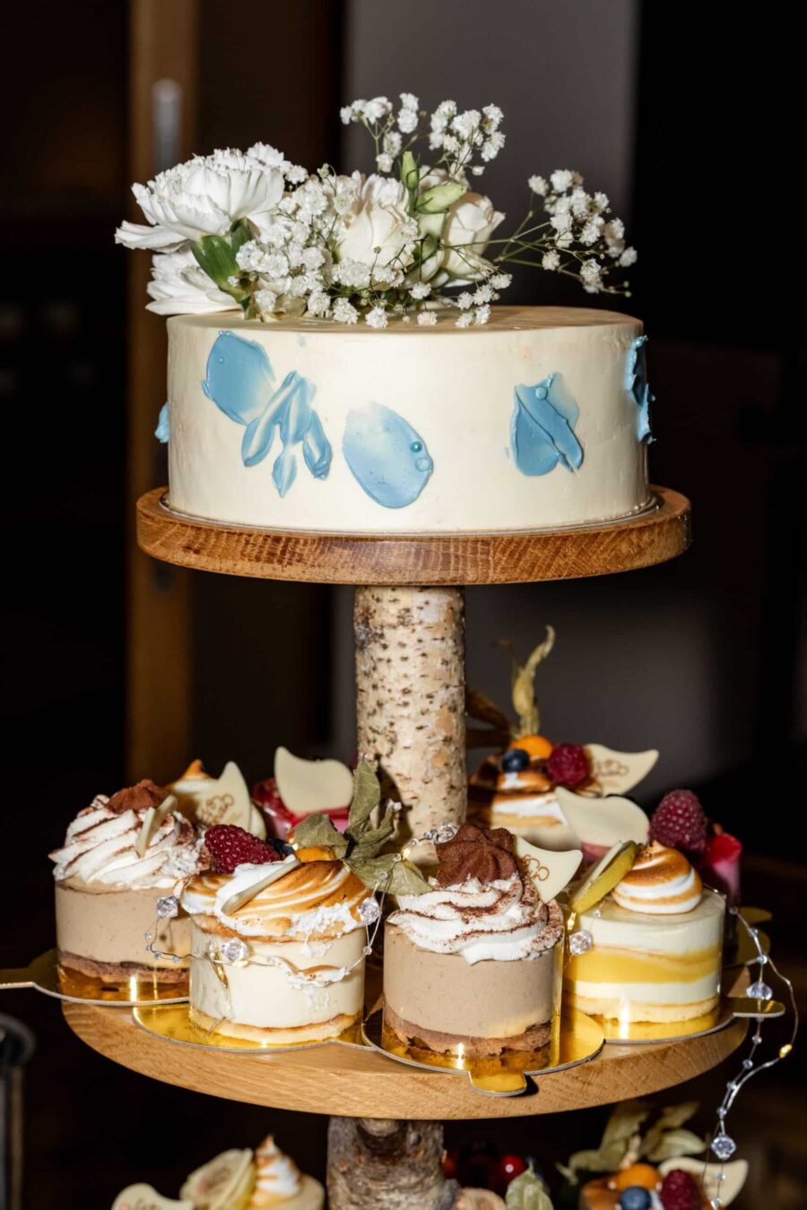 Hochzeitstorte mit blauen Verzierungen und Blumen.